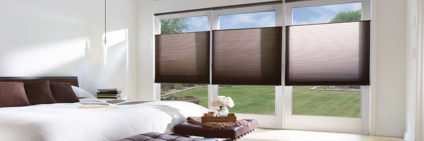 Brown window shades in a white bedroom